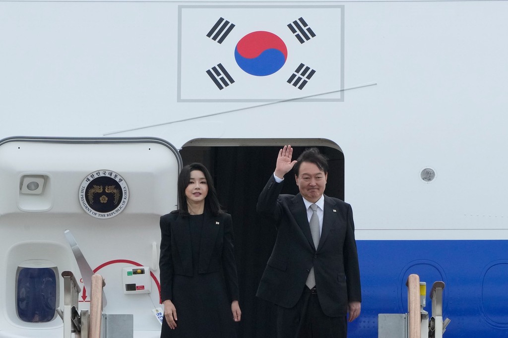 Yoon Suk Yeol dél-koreai elnök integet, miközben felesége, Kim Keon Hee társaságában Londonba indul, hogy részt vegyen II. Erzsébet királynő temetésén.