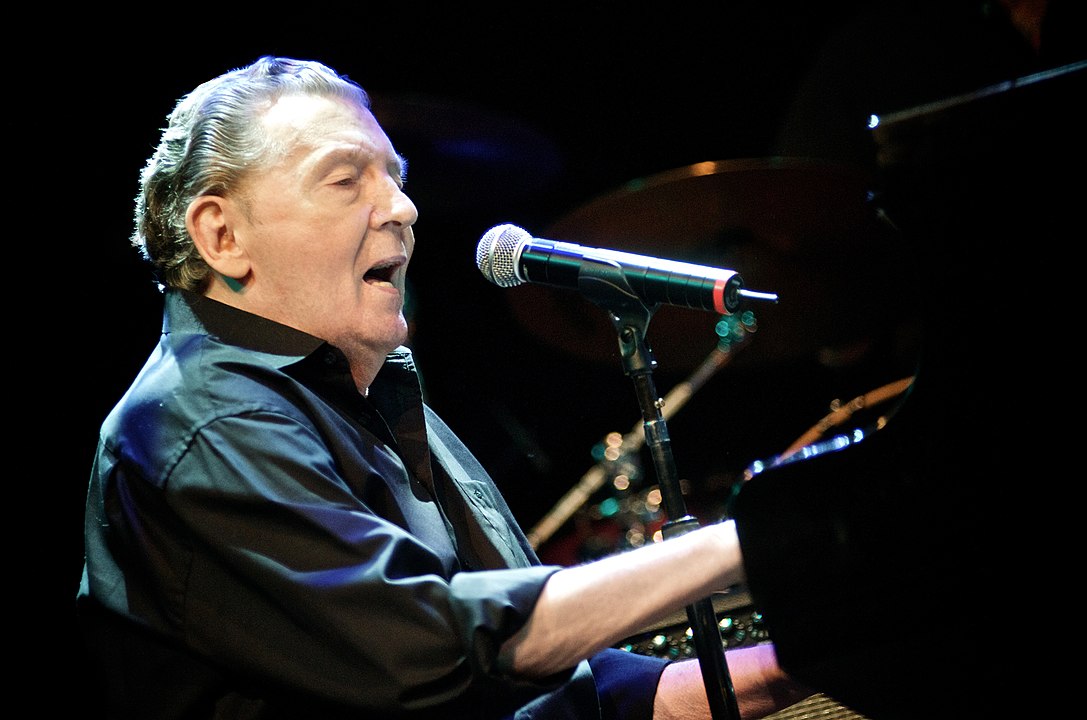 Jerry Lee Lewis amerikai rock and roll- és country-énekes, zongorista (87).  Beceneve a „Killer”(Gyilkos), melyet egyedi zongorajátékával érdemelt ki. Egyediségéhez őrült színpadi produkciója is hozzájárult, melyben gyakran táncolva játszott, a zongorára ugrott, vagy éppen felgyújtotta azt. A Rolling Stone Magazin 24. helyre rangsorolta az énekest a Minden Idők 100 Legnagyobb Művésze listán. (Fotó: Wikipedia/Silvio Tanaka) 