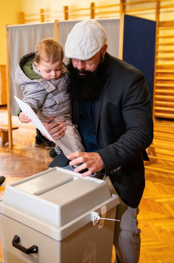 Gődény György, a Normális Élet Pártjának elnöke unokájával karjában adta le szavazatát a nyíregyházi Tündérkert Keleti Óvoda Koszorú úti Telephelyén – Fotó:  MTI/Balázs Attila 